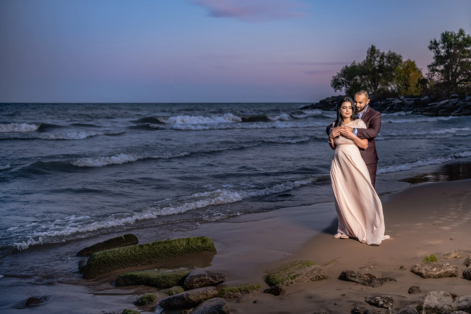 A couple embracing beside the lake at dusk